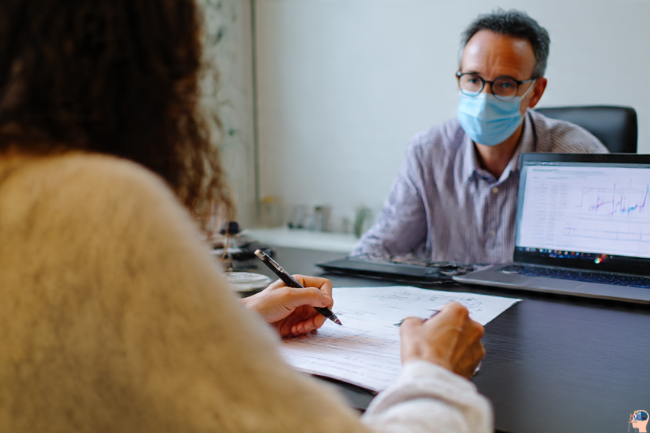Medical professional reviewing health data with a patient in a bright office during a follow-up consultation for progress evaluation.