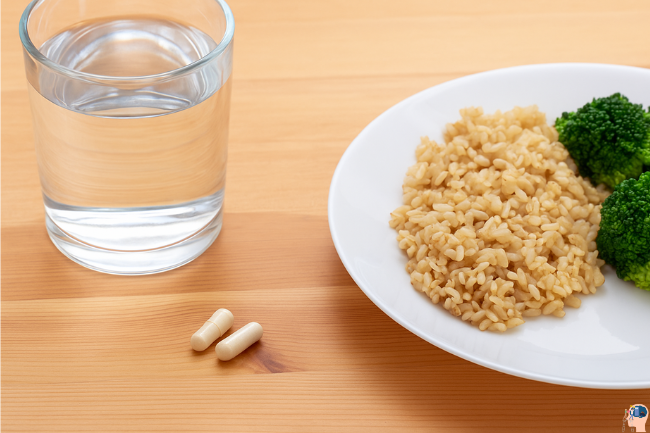 Two Osteopur capsules beside a glass of water and a healthy meal plate, symbolizing safe usage and recommended dosage.